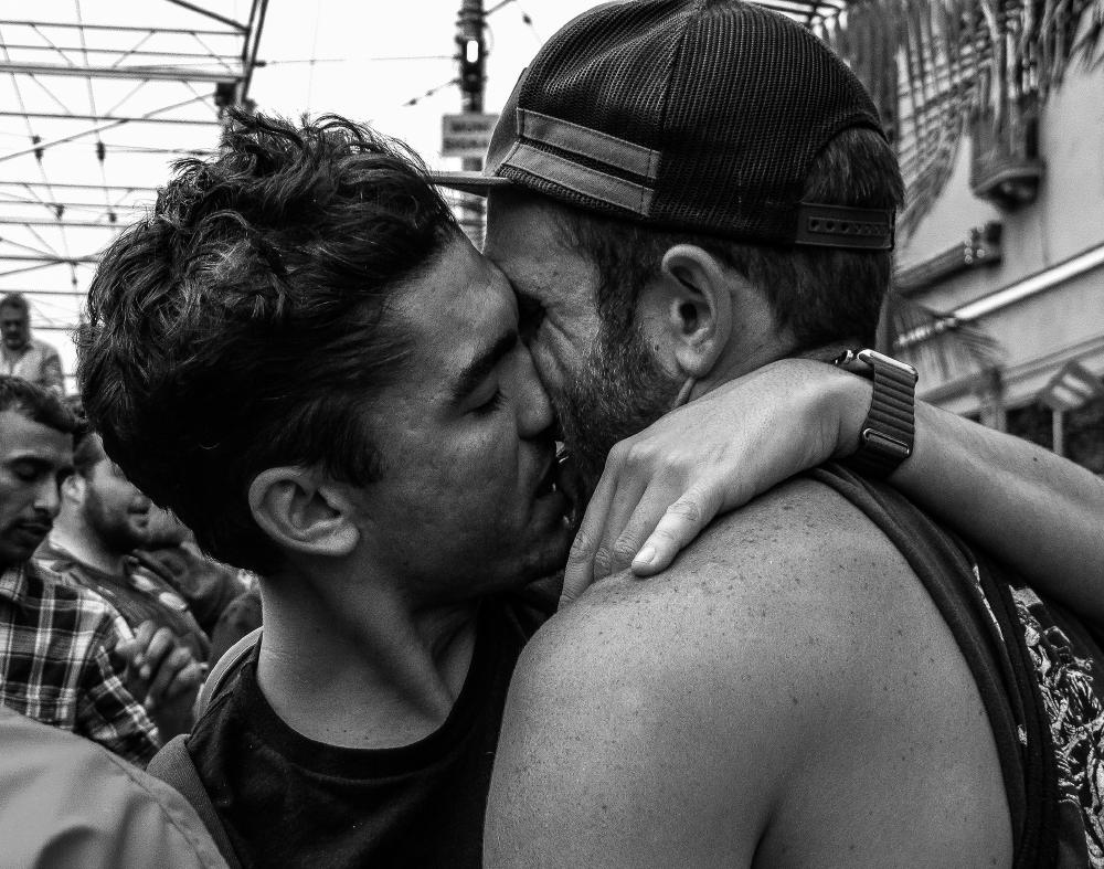 Men kissing Castro Street on the day before Pride week-end